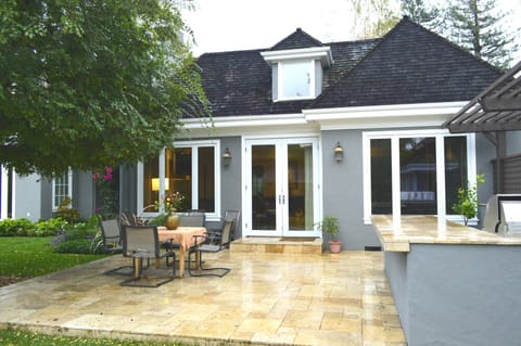 Tiles backyard patio in between BBG Grill and swimming pool.