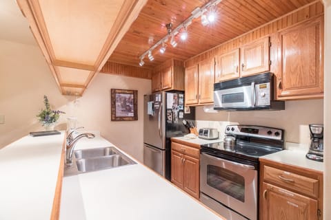 Kitchen with plenty of dishes, pot & pans. Condiments.