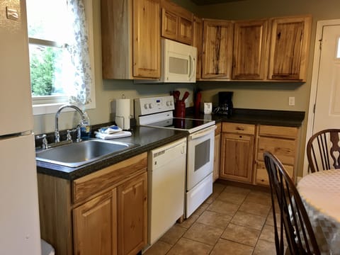 Kitchen has a fridge, stove, dishwasher, microwave, coffee maker, and a toaster