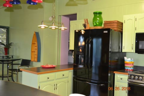 Three door frig and entrance to pink bedroom.  Complete kitchen in this space.