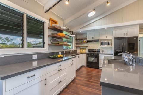 Remodeled kitchen with updated appliances, spacious fridge and island counter.