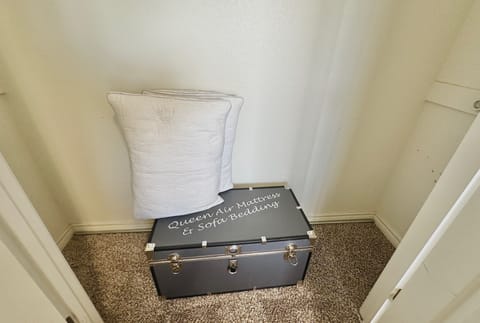 Air mattress and linens in closet in bunk room.