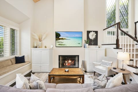 The living room has multiple seating areas, a large Smart TV, and a fire place to cozy up with in the cooler months.