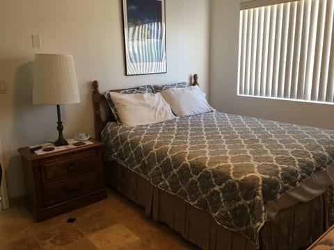 bedroom 2 has a queen sized bed, ceiling fan and office desk