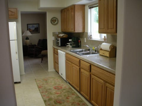 Kitchen with granite countertops looking into the living room.