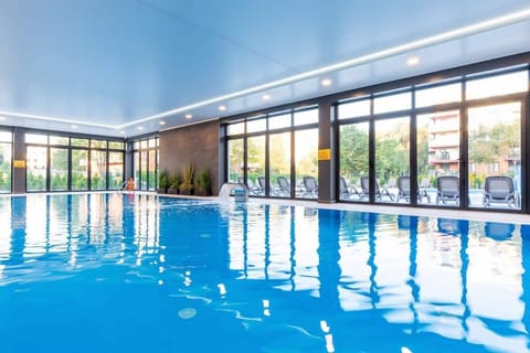A large bright space where there is an indoor swimming pool.