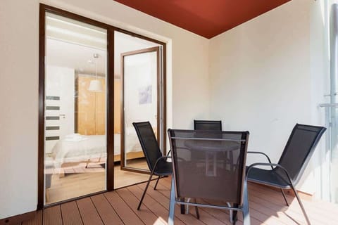 Balcony with tables and chairs that provide a comfortable space for relaxing outdoors.
