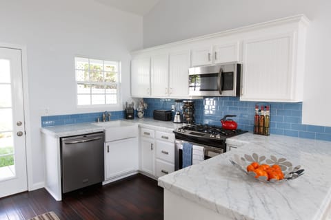 Bright kitchen with marble countertops, fully stocked to cook for 8