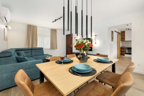 The elegant table with designer lamps above it adds a modern and stylish character to the interior.