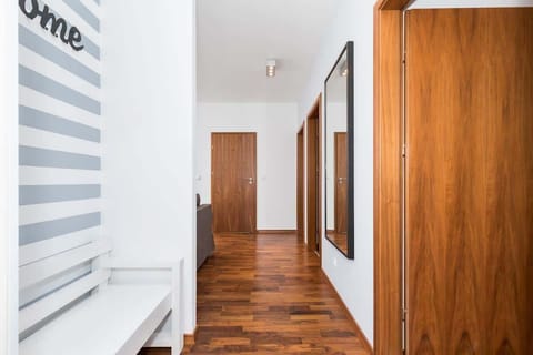 Hallway with white walls and a white wardrobe from which the entrance to the rooms leads.