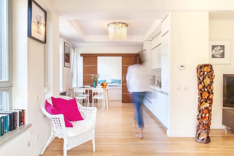 A bright kitchenette with white cabinets next to a simple dining table, creating a cozy spot for meals.