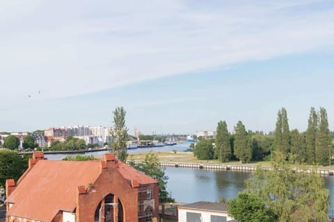 An angled view of a balcony with a railing, overlooking neighboring houses or buildings.