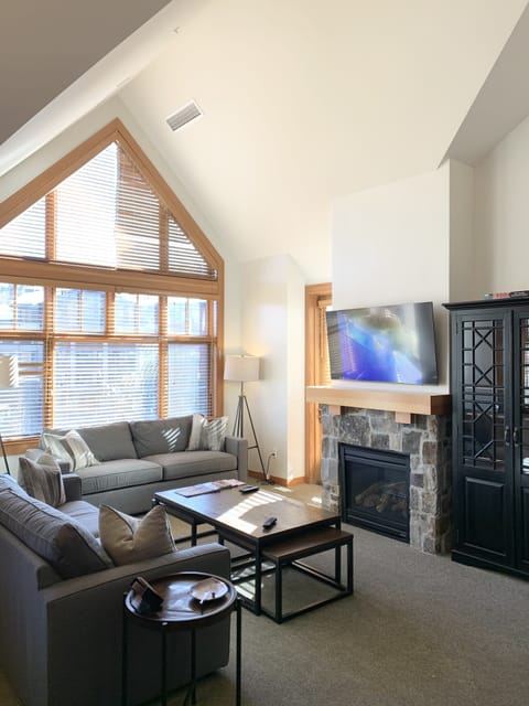 Open living room w/ gas fireplace samsung 4K smart tv and pullout queen sleeper.