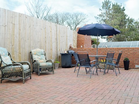 Enclosed courtyard with patio and sitting-out area | The Snug, Caergeiliog, near Holyhead