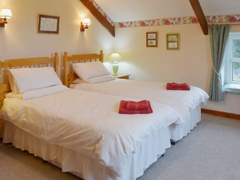 Twin bedroom with sloping and beamed ceiling | The Stables, Carthamartha, near Launceston