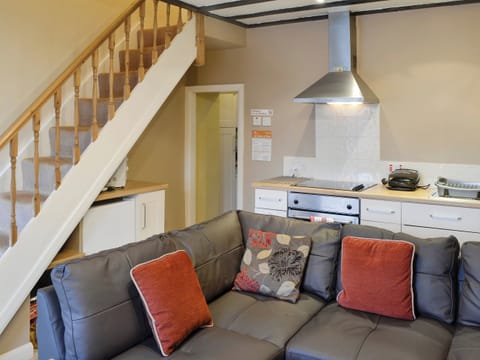 Comfy seating in living area and stairs to upper level | Tan y Bryn, Prenteg, near Porthmadog