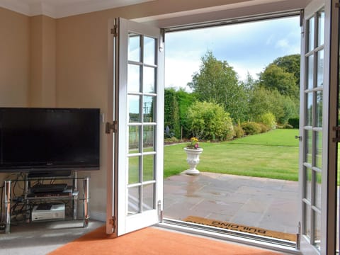Cosy living room with bi-folding doors leading to patio | The Old Gasworks Building - Old Montrose, Montrose