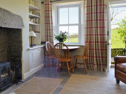 Living room with wood-burner and door to garden | Gardenwell Cottage, Burtersett, near Hawes