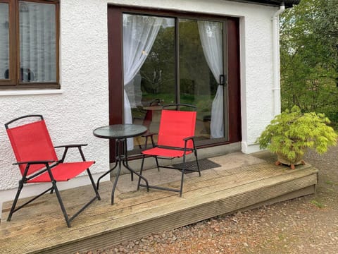 Decked patio area looking out on to unspoilt woodland grounds | Crossburn Hideaway, Arden, near Helensburgh