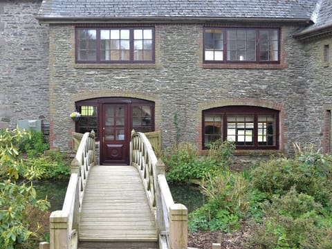 Quirky wooden footbridge access | Bridge House - Lower North Radworthy Cottages, Heasley Mill, near South Molton