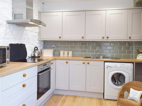 Galley style kitchen with breakfast bar | Moss Cottage, Burry Port, near Llanelli