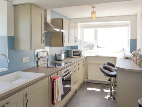 Fully equipped fitted kitchen with breakfast bar | Bwthyn Y Borth, Rhoscolyn, near Holyhead