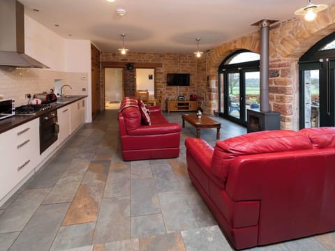Cosy living area with wood-burning stove and large arched windows | Cart Shed, Mauchline, near Ayr