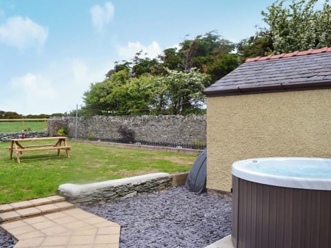 Enclosed lawned garden with sitting-out area, garden furniture and private hot tub | Yr Hen Stabal - Bronallt Barns, Llanynghenedl, near Holyhead