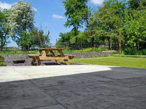 Lawned garden with patio and furniture | The Mill Farmhouse (Ty Fferm Y Felin), Llandybie, near Llandeilo