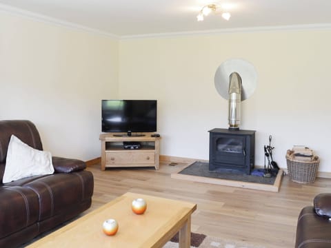 The spacious living room boasts a wood-burning stove | March Cottage, Glen Cassley, near Lairg