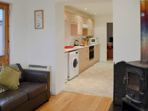 Wood burner in the sun room, leading into kitchen | Birch Tree Cottage, Aviemore, Speyside
