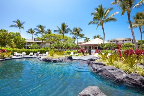 Sparkling lagoon style pool with rock accents and palm trees.