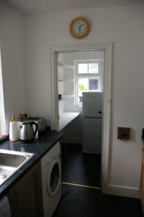 Kitchen with washer and dishwasher, looking into pantry.
