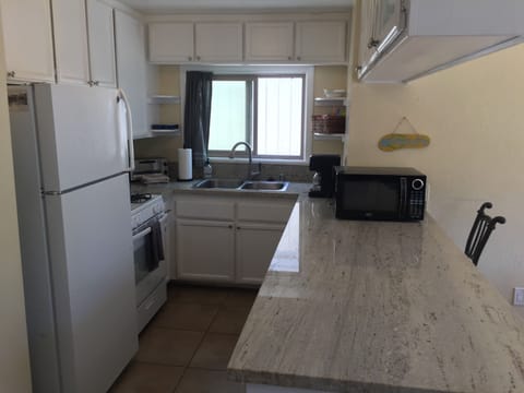 Kitchen area with counter, seats 3 people. Dining table adjacent but not shown.