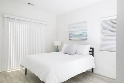 Bedroom 1 with sliding door to shared patio, offering peaceful views of olive orchard and trees.