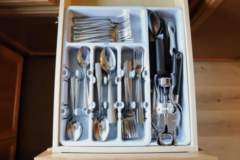 The kitchen is well stocked with cookware, utensils, silverware, and glassware. 