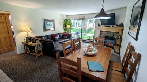 Living room with sofa bed, dining table, gas fireplace, and patio w/ gas BBQ