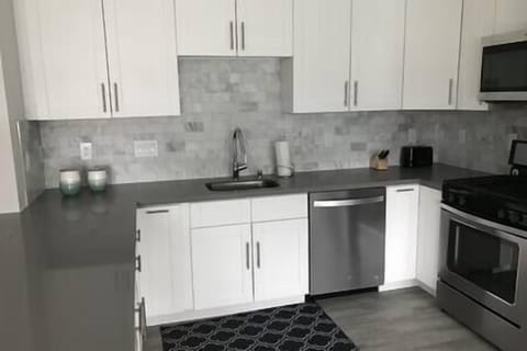 Fully-stocked kitchen with gas stove, oven, microwave, dishwasher, and Keurig, perfect for cooking.