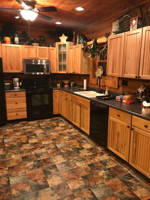 Kitchen with appliances large and small and variety of cookware.