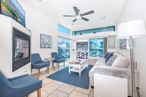 Main living area, located on the middle level includes seating, fireplace, TV, ceiling fan and sliding glass door to front ocean view balcony.