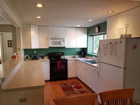 Large kitchen with plenty of dishes, pots, and counter space