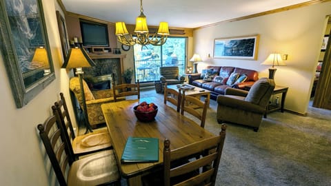 Living room with sofa bed, gas fireplace, dining table, and balcony w/ gas BBQ