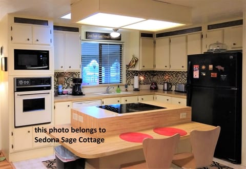 Open kitchen with island cooktop and seating (and plugs for devices).
