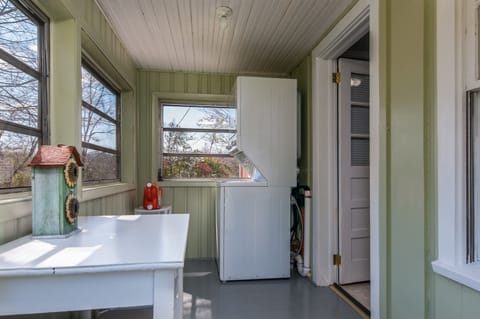 ENCLOSED PORCH - Adjacent to Kitchen, includes washer/dryer, desk/table, stools.