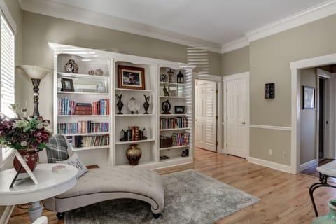 Library with view of main floor hallway to king master suite and hall to kitchen