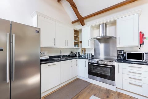 The open plan kitchen features an American fridge freezer and a range cooker as well as all the equipment you would expect