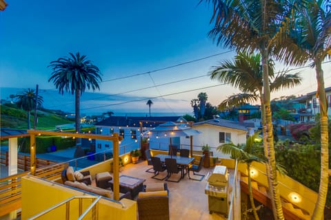Sun deck with BBQ, market lights, ocean view and steps to sand.