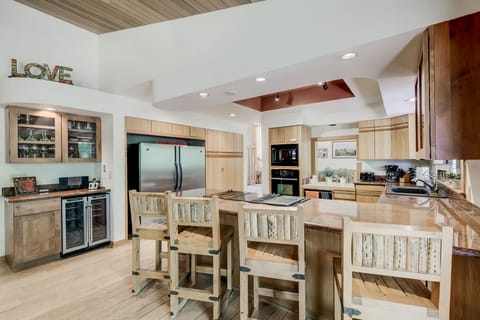 Double fridge, bar, pantry, open kitchen, door to back deck & yard.