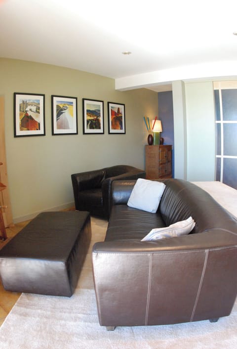 Spacious living room with leather chair and sofa.