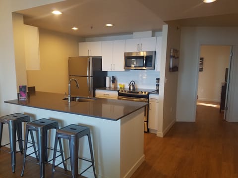 Harbor Steps NE 2201 kitchen, with queen bedroom (w/ TV) beyond